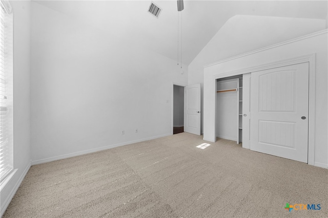 unfurnished bedroom featuring ceiling fan, light colored carpet, a closet, and high vaulted ceiling