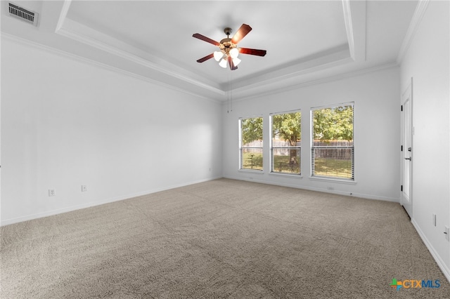 empty room with ceiling fan, crown molding, carpet floors, and a raised ceiling