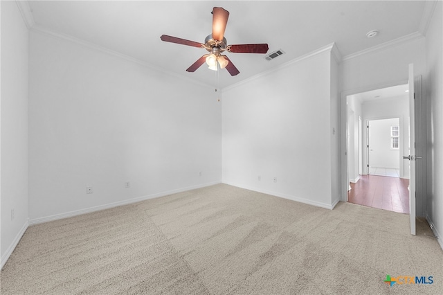 carpeted spare room featuring ceiling fan and crown molding