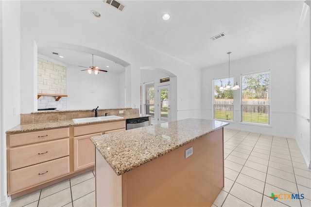 kitchen with light brown cabinetry, decorative backsplash, sink, dishwasher, and ceiling fan with notable chandelier