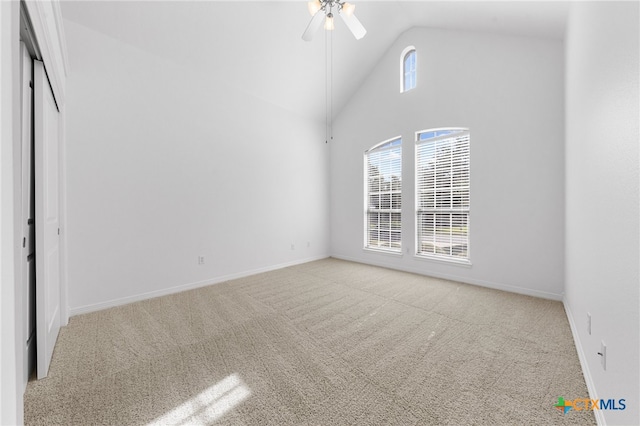 interior space featuring ceiling fan, light colored carpet, and high vaulted ceiling