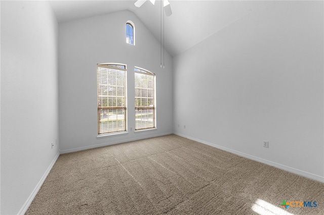 carpeted spare room featuring high vaulted ceiling, a wealth of natural light, and ceiling fan