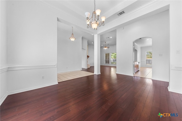 empty room with hardwood / wood-style flooring, ornamental molding, and ceiling fan with notable chandelier