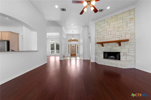 unfurnished living room with dark hardwood / wood-style flooring, ceiling fan with notable chandelier, ornamental molding, and a fireplace