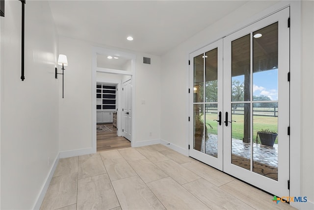 doorway to outside with french doors and light wood-type flooring