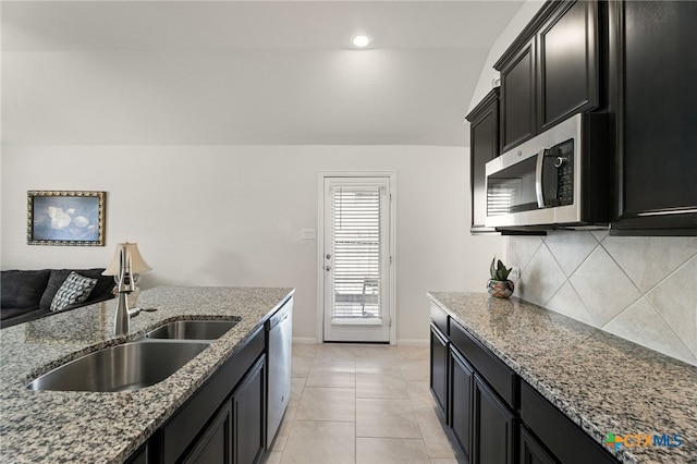 2233 Sauterne Dr, Leander, TX 78641 - kitchen with stainless steel appliances, a sink, dark cabinetry, decorative backsplash, and recessed lighting