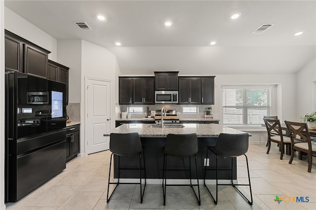 2233 Sauterne Dr, Leander, TX 78641 - kitchen with stainless steel microwave, freestanding refrigerator, vaulted ceiling, decorative backsplash, and recessed lighting