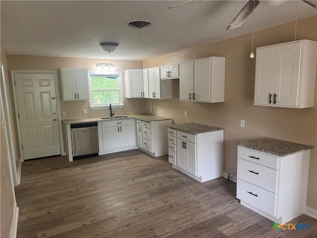 1315 S 51st St, Temple, TX 76504 - kitchen with stainless steel dishwasher, a sink, dark wood-style floors, and white cabinets
