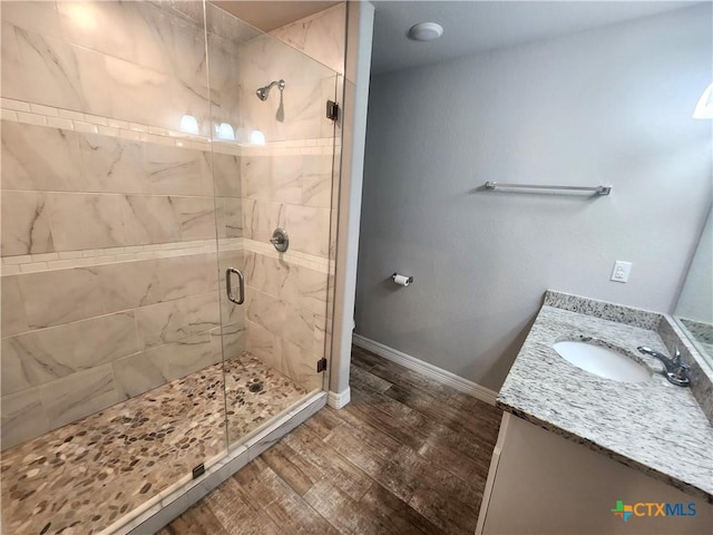 bathroom featuring an enclosed shower, vanity, and wood-type flooring