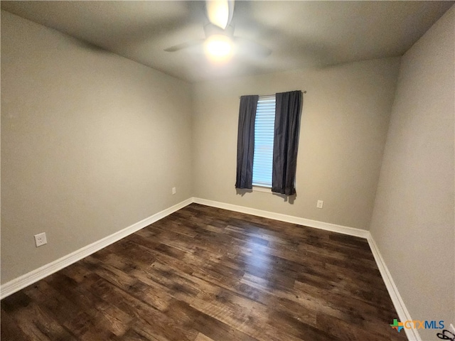 empty room featuring dark wood-type flooring and ceiling fan