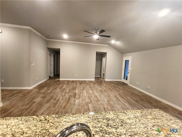 interior space featuring wood-type flooring, vaulted ceiling, ornamental molding, and ceiling fan