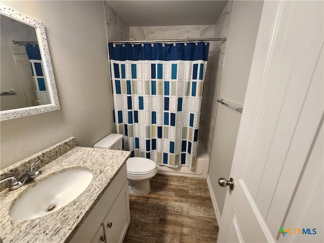 full bathroom with vanity, hardwood / wood-style flooring, shower / bath combination with curtain, and toilet