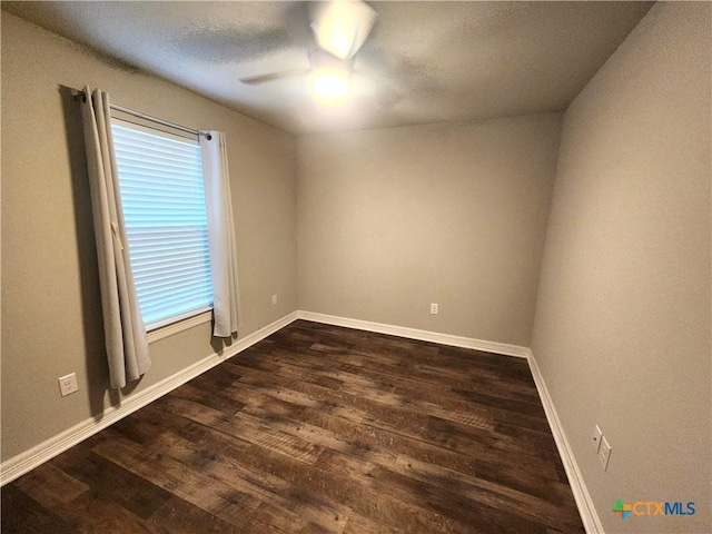 spare room with ceiling fan and dark hardwood / wood-style flooring