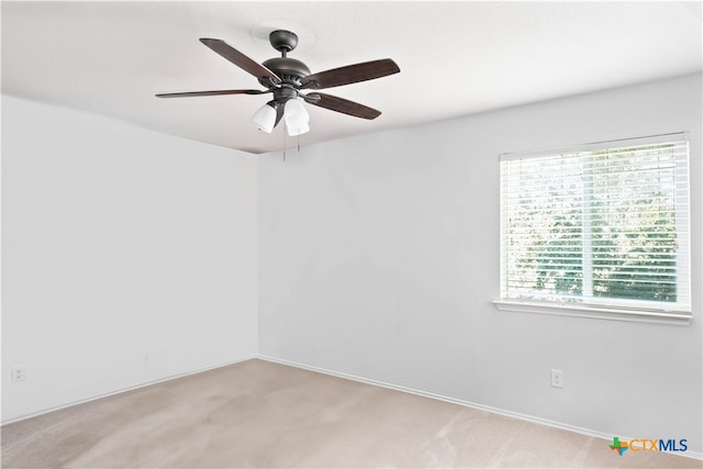 spare room featuring light carpet and ceiling fan