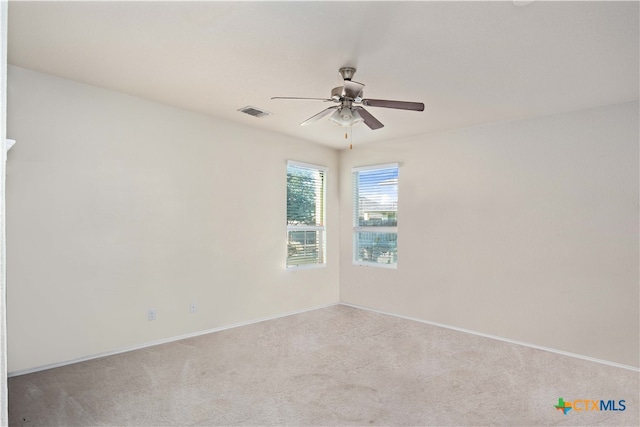 carpeted spare room featuring ceiling fan