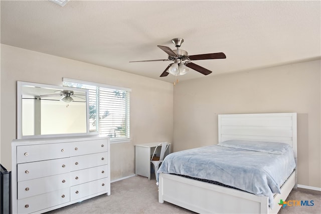 carpeted bedroom featuring ceiling fan and a textured ceiling