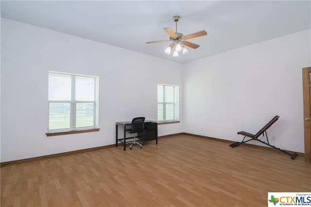 unfurnished office with light hardwood / wood-style floors, ceiling fan, and a healthy amount of sunlight