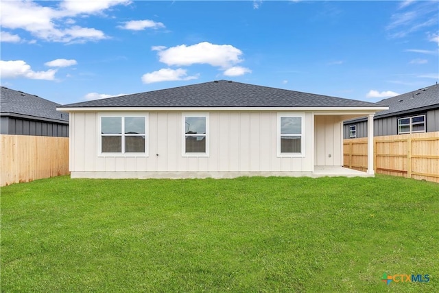 rear view of property with a lawn