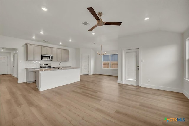 kitchen with appliances with stainless steel finishes, ceiling fan with notable chandelier, a center island with sink, light hardwood / wood-style flooring, and gray cabinets