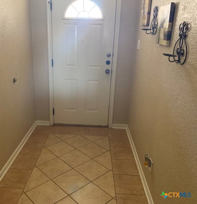 doorway to outside featuring light tile patterned flooring