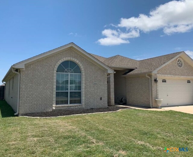 ranch-style home with a garage and a front lawn