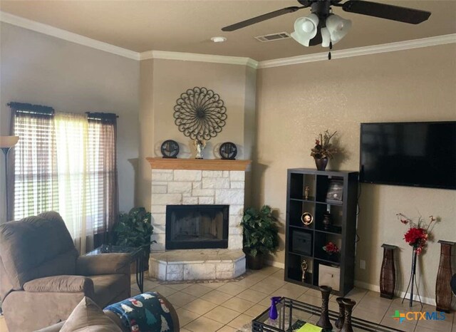 living room featuring a fireplace, light tile patterned flooring, ceiling fan, and crown molding