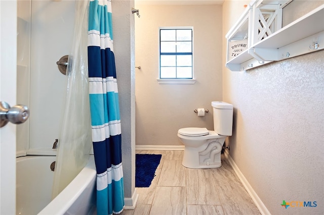 bathroom with shower / tub combo with curtain and toilet