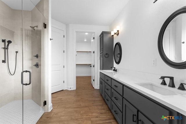 4121 Turning Leaf Dr, Nolanville, TX 76559 - bathroom with a stall shower, wood finished floors, double vanity, and a walk in closet