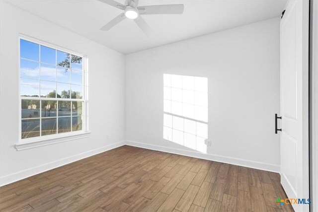 4121 Turning Leaf Dr, Nolanville, TX 76559 - unfurnished bedroom with a barn door, baseboards, light wood finished floors, and a sink
