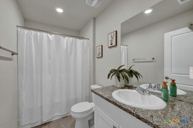 bathroom with visible vents, toilet, recessed lighting, and vanity