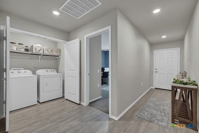 laundry area featuring baseboards, visible vents, independent washer and dryer, laundry area, and wood finished floors