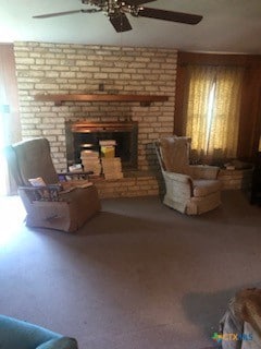 living room with carpet, ceiling fan, and a fireplace