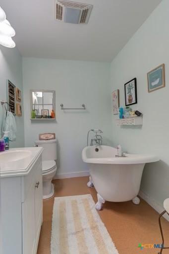 162 Canyon Crk, Canyon Lake, TX 78133 - bathroom featuring visible vents, baseboards, toilet, vanity, and a freestanding bath