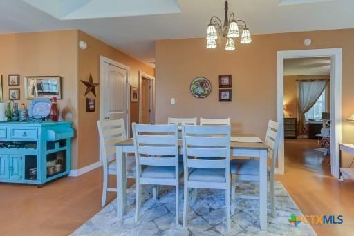 162 Canyon Crk, Canyon Lake, TX 78133 - dining area with an inviting chandelier, baseboards, and wood finished floors