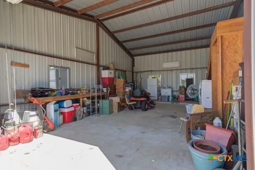 162 Canyon Crk, Canyon Lake, TX 78133 - garage featuring metal wall, washer / dryer, and freestanding refrigerator
