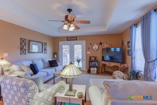 162 Canyon Crk, Canyon Lake, TX 78133 - living area with french doors, a raised ceiling, a healthy amount of sunlight, and ceiling fan