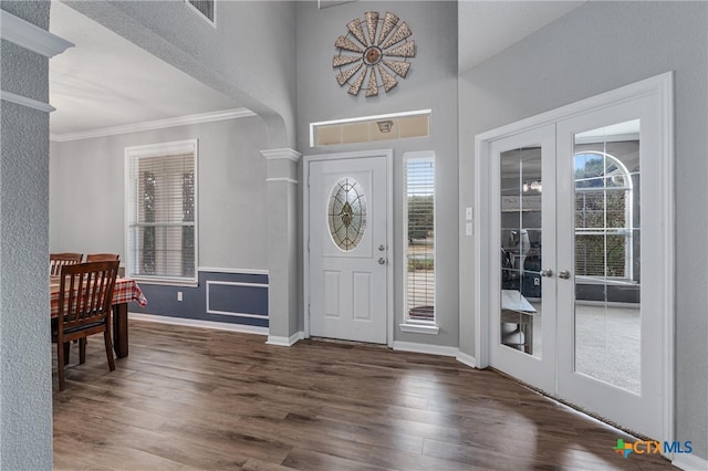 foyer entrance with ornamental molding, french doors, and dark wood-type flooring