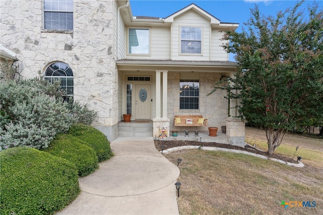 view of front of home featuring covered porch and a front lawn