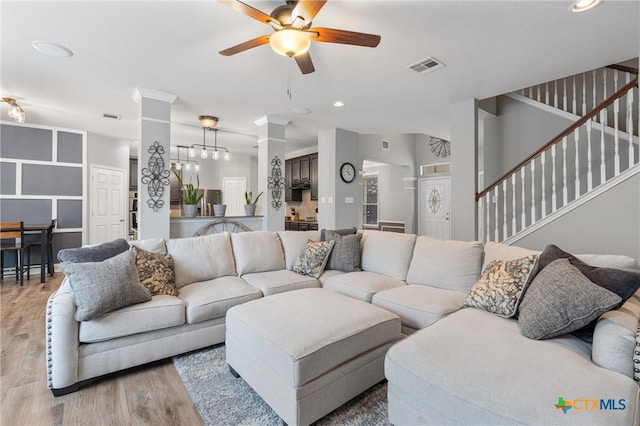 living room with light hardwood / wood-style floors and ceiling fan