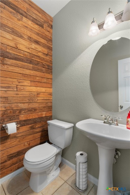 bathroom featuring wood walls, tile patterned floors, and toilet