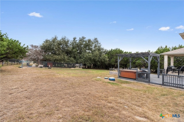 view of yard with a hot tub and a pergola