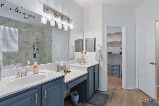 bathroom featuring vanity, hardwood / wood-style flooring, and a tile shower