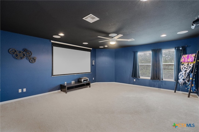 home theater room with a textured ceiling, ceiling fan, and carpet floors