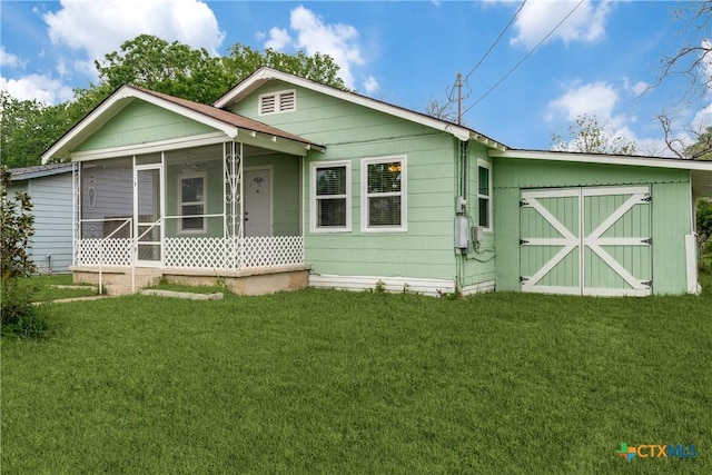 view of front of home featuring a front yard and a sunroom