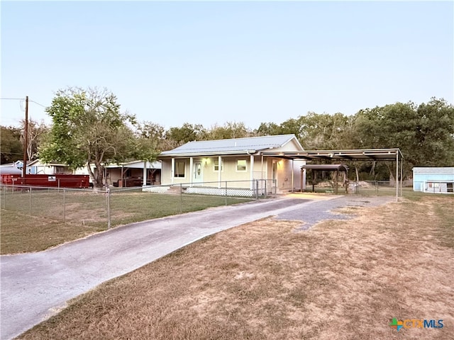 view of front facade with solar panels, a front lawn, and a carport