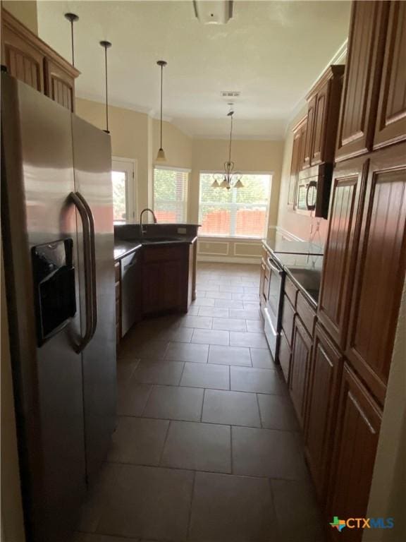 kitchen with sink, hanging light fixtures, stainless steel appliances, tile patterned floors, and a chandelier