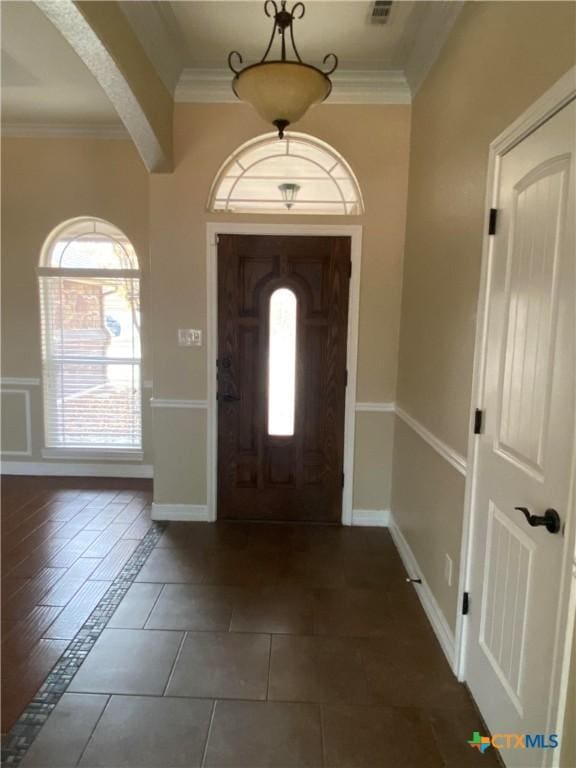 tiled foyer featuring ornamental molding