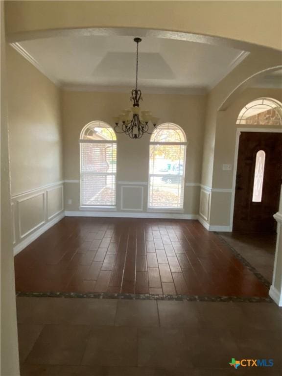 entryway featuring a notable chandelier, wood-type flooring, and crown molding