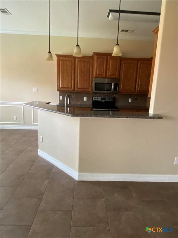 kitchen featuring tile patterned flooring, stainless steel appliances, and hanging light fixtures