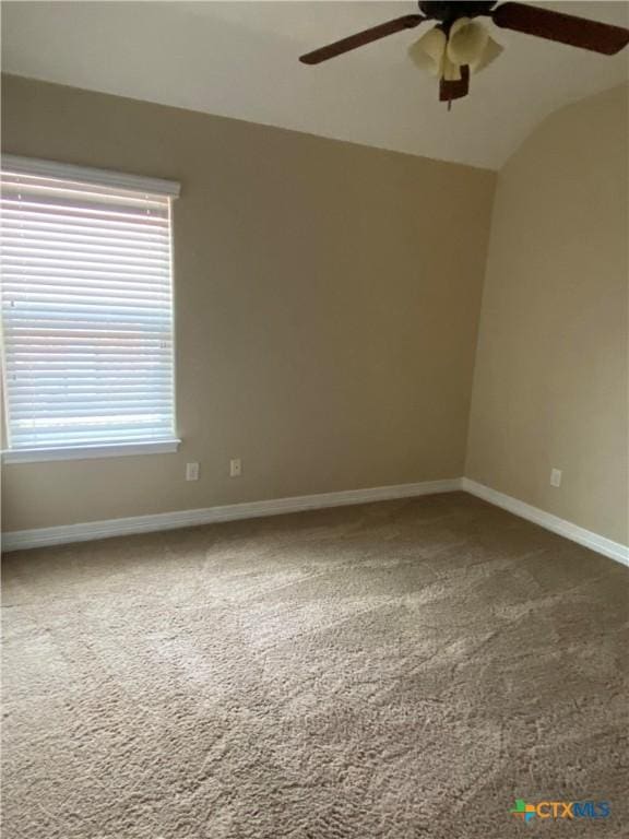 carpeted empty room featuring ceiling fan and vaulted ceiling